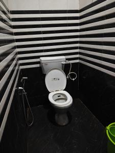 a bathroom with a toilet with black and white stripes at Krishna guest House - 600 meter away from ram mandir in Ayodhya