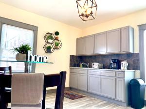 eine Küche mit weißen Schränken und einem Tisch und Stühlen in der Unterkunft 5BR Niagara Getaway Prime Location-Sleeps 10 in Niagara Falls