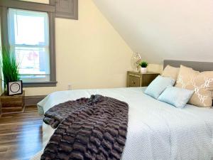 ein Schlafzimmer mit einem Bett mit einer Decke darauf in der Unterkunft 5BR Niagara Getaway Prime Location-Sleeps 10 in Niagara Falls + 15 Fotos