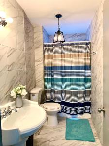 ein Badezimmer mit Waschbecken, Toilette und Dusche in der Unterkunft 5BR Niagara Getaway Prime Location-Sleeps 10 in Niagara Falls