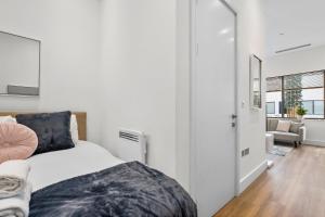 a bedroom with a bed and a living room at The Cosy Luxe in Slough