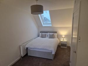 エディンバラにあるEdinburgh West Luxury 5 Bedroom Homeの窓付きのベッドがある小さな寝室 +1枚の写真