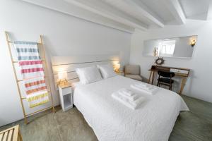 une chambre blanche avec un lit blanc et un bureau dans l'établissement BIOMA Adega - Escala Gourmet, à Calheta de Nesquim