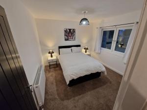 エディンバラにあるEdinburgh West Luxury 5 Bedroom Homeの白いベッドと窓のある寝室