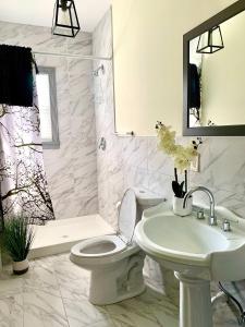 a white bathroom with a toilet and a sink at Perfect 6BR Stay Near Falls & Attractions in Niagara Falls +11 photos