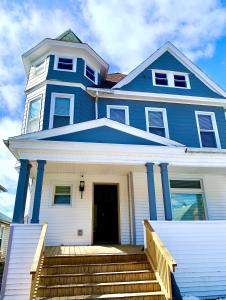 a blue house with stairs in front of it at Perfect 6BR Stay Near Falls & Attractions in Niagara Falls