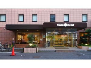 une devanture de magasin avec un vélo garé à l'extérieur dans l'établissement Smile Hotel Tokyo Ayase Ekimae - Vacation STAY 62854v, à Tokyo