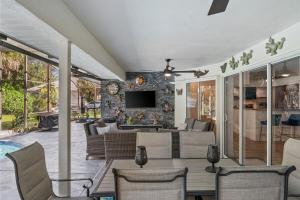 a patio with a table and chairs and a tv at Sunset Sands Retreat in Venice