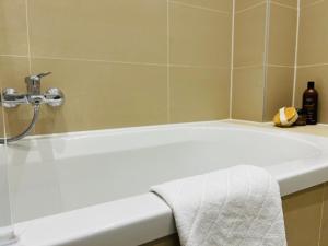 une salle de bain avec une baignoire et un lavabo dans l'établissement APSTAY City Prime I Parking option I Self Check-in, à Graz