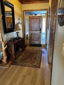 a hallway with a wooden door and a table and a mirror at 7 Bdr 5 ba Amazing View Amenities Fido can join in Eden