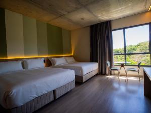 Liwe Hotels في بنها: غرفة فندقية تحتوي على سريرين وطاولة وكراسي +59 صورة