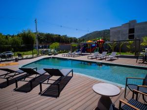 una piscina con sedie e un tavolo e un parco giochi di Liwe Hotels a Penha