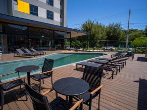 Liwe Hotels في بنها: سطح بطاولات وكراسي بجانب مسبح