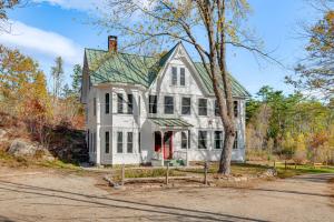 a white house with a red door at Spacious Home on Bear Camp River in Tamworth! in Tamworth