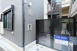 Una puerta negra frente a un edificio con un cartel de "Se alquila". en le cocon Nakarokugo - Vacation STAY 17419v, en Tokio