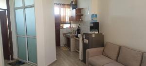 a living room with a couch and a kitchen at Cozy one bedroom in Mombasa