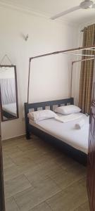a bed in a room with a mirror and a bed sidx sidx sidx at Cozy one bedroom in Mombasa