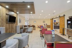 a restaurant with tables and chairs and a flat screen tv at Holiday Inn Express Hotel & Suites Torrington by IHG in Torrington