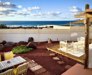 eine Terrasse mit Tisch und Stühlen und dem Meer in der Unterkunft Apartamento vintage en Playa Famara in Famara