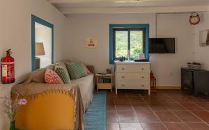 ein Wohnzimmer mit einer Couch und einem Fenster in der Unterkunft The Yellow Cottage Nature House São Vicente Madeira Island in São Vicente