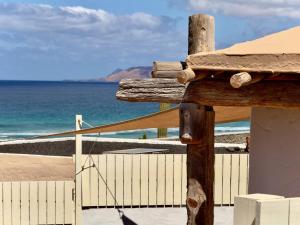 ein Holzkreuz vor einem Strand in der Unterkunft Apartamento vintage en Playa Famara in Famara