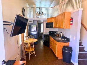 a kitchen with a television and a table with a dining room at Cedar Tiny Home in Woodland Park
