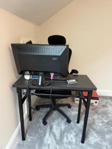 a desk with a computer monitor and a keyboard at Birch view getaway in Dunshaughlin