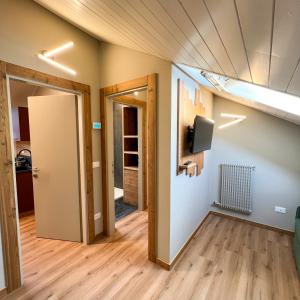 an empty room with a door and a room with a tv at Harmonia Suite & Apartments in Giustino