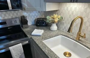 a kitchen counter with a sink and a vase of flowers at North Conway area 2 bedroom updated condo in Bartlett +7 photos