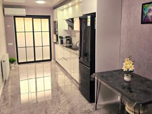 a large kitchen with a table and a counter at Two-Bedroom Apartment in Kutaisi Nest 1, New Linen, Free Parking in Kutaisi