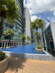 a large swimming pool with palm trees in a city at vortex luxury apartment klcc in Kuala Lumpur