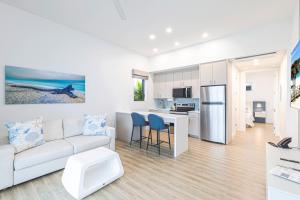 a white living room with a couch and a kitchen at Shalimar Beach Resort in Sanibel
