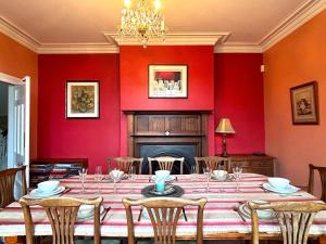 a dining room with a table and red walls at Spacious 4-Bed Home - Oswestry - Families & Groups in Oswestry