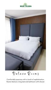 a bed with a blue headboard and white sheets at Marikana guest house 