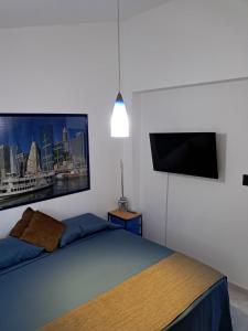 ein Schlafzimmer mit einem Bett und einem Flachbildfernseher in der Unterkunft Apartamento con vista al mar Tucacas in Tucacas