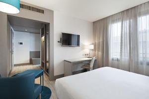una habitación de hotel con una cama y un escritorio en NH Parma, en Parma 22 fotos más