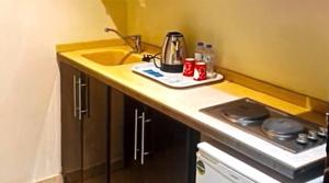 uma cozinha com pia e bancada em فندق الخلفاء الفضي الفندقية em Al Khansāk mais 7 fotografias