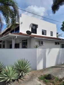 a white house with a white wall at RUMAH BENDANG ALOQSETAQ -Private PooL - Panoramic view of rice fields and Alor Setar Tower in Alor Setar