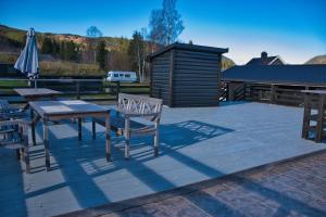 Un patio con una mesa y sillas y una sombrilla. en Ringen Camping, en Vestre Gausdal