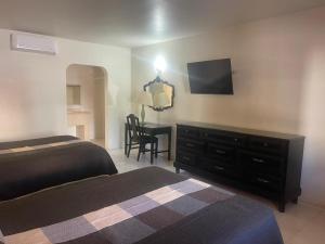een slaapkamer met een bed, een dressoir en een bureau bij Hotel Colonial 