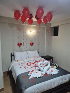 una cama con globos rojos colgando del techo en Hotel Naciones Unidas, en Lima