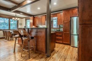 eine Küche mit Holzschränken und eine Bar mit Hockern in der Unterkunft Cedar Crest - Owl Cottage 9 in Homewood