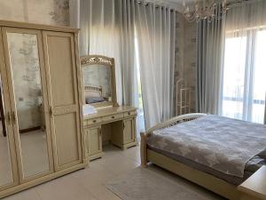 a bedroom with a bed and a dresser and a mirror at Коттедж - Вилла in Chok-Tal