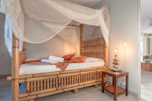 ein Bett mit Baldachin in einem Zimmer in der Unterkunft La Villa Cocoon prestige et vue mer in Sainte-Luce + 57 Fotos