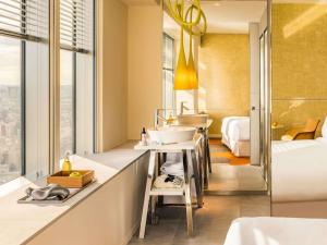 a bathroom with a sink and a bedroom at Too Hotel & Spa Paris - MGallery Collection in Paris