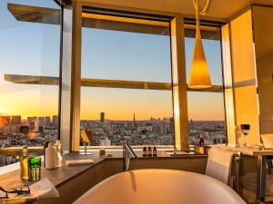 a bathroom with a tub and a view of a city at Too Hotel & Spa Paris - MGallery Collection in Paris