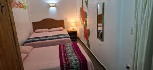 ein kleines Schlafzimmer mit 2 Betten und einem Spiegel in der Unterkunft CASITA MADAME in Puerto López