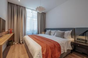 a bedroom with a large bed and a television at Artifact Apart Hotel in Tbilisi City