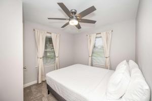 a white bedroom with a ceiling fan and two windows at Valley Ridge Retreat - For 8 in Cincinnati