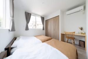 une chambre avec deux lits, un bureau et une chaise dans l'établissement Musashino - House - Vacation STAY 20327, à Musashino